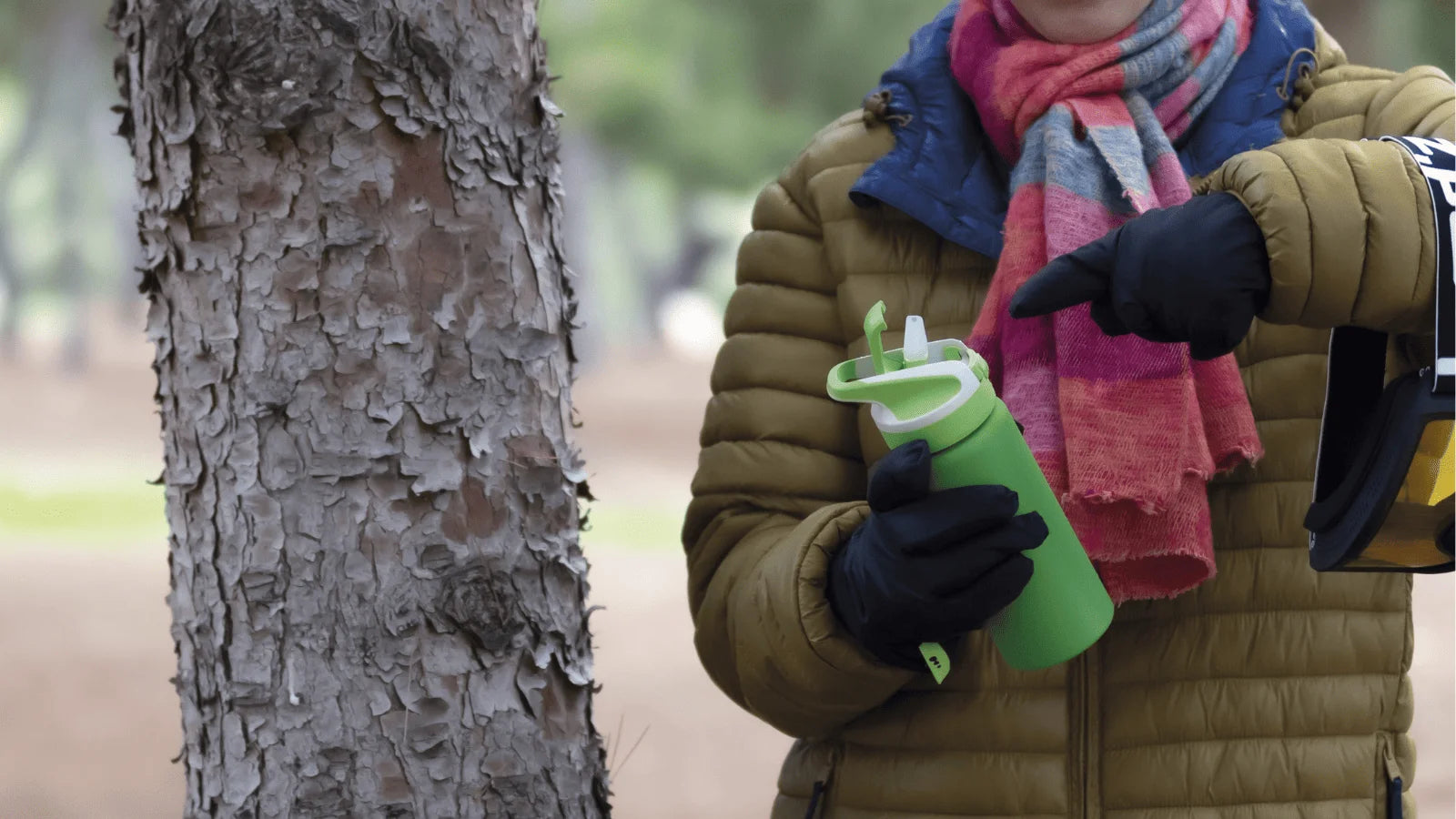 Mujer sosteniendo una botella Summit abierta en medio del bosque