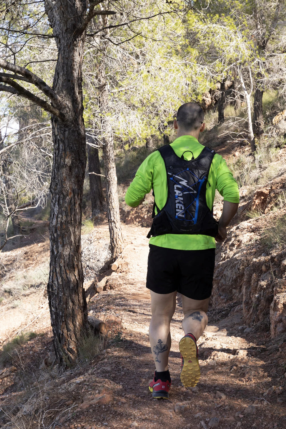 Corredor con mochila LAKEN Towada 15 por el sendero de una montaña